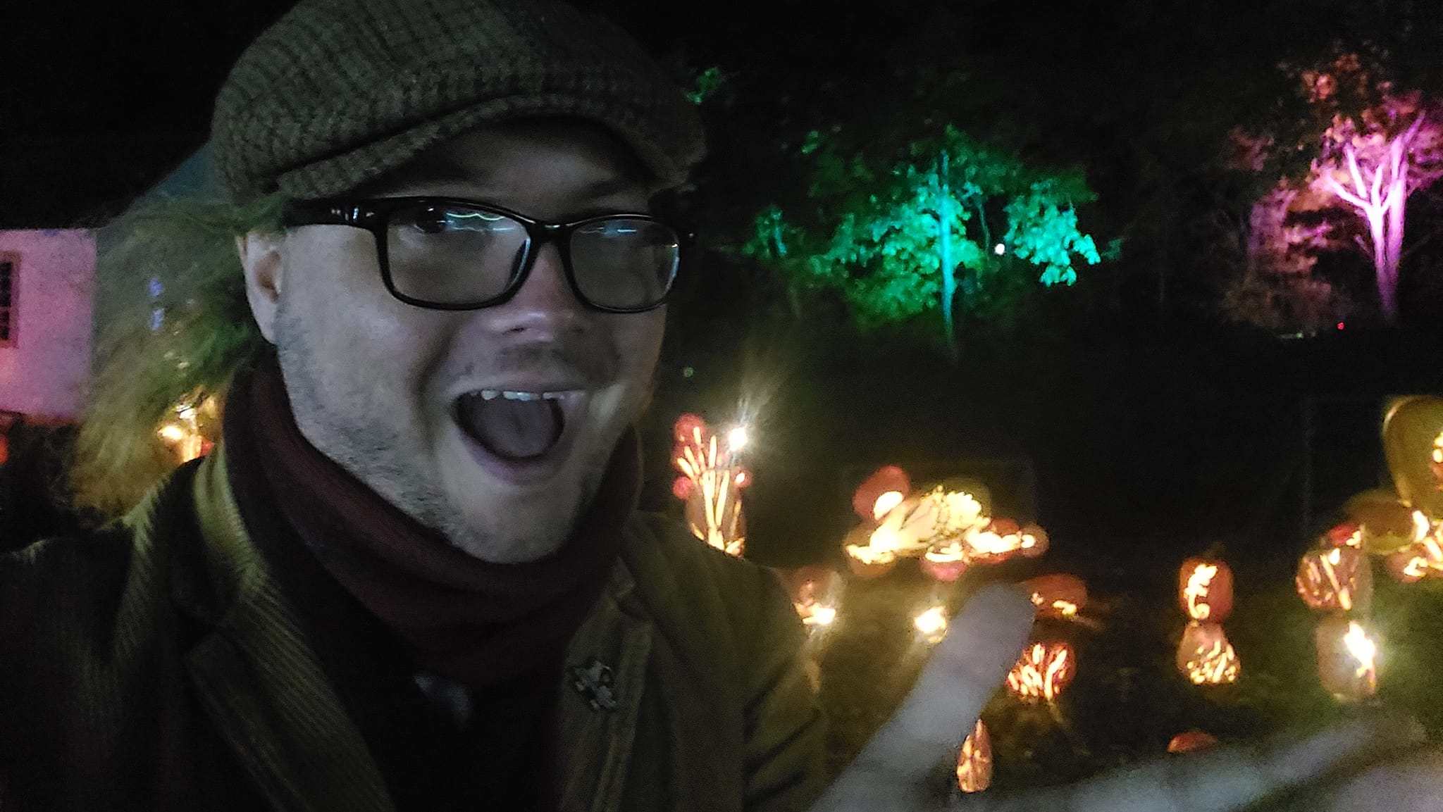 A blurry man stands in front of a swan made of jack-o-lanturns